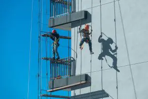 couple workers fixing climbing scaffolding while following all safety measures Armaq